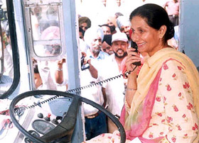Patiala MP Preneet Kaur tries her hand at the telephone which comes with the GPIS system being installed in PRTC buses in Patiala on Thursday.
