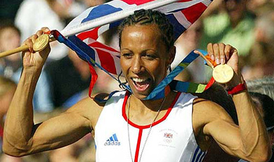Kelly Homes, British Olympic gold medalist for the 800 and 1500 meters, shows off her medals as she takes a tour of her home town, Tonbridge, England