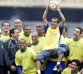 Brazilian football players hold up Brazilian marathon runner Vanderlei de Lima at Morumbi station in Sao Paulo