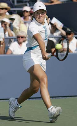 Justine Henin-Hardenne hits a return to Lisa Raymond during the US Open