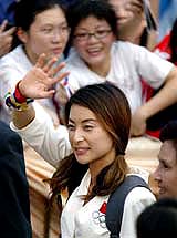 Guo Jingjing, Chinese diver who won two gold medals at the Olympic Games in Athens, waves to fans on her arrival in Hong Kong