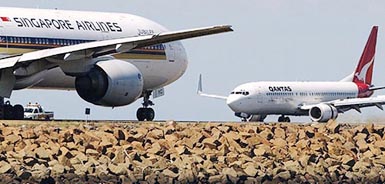 Qantas and Singapore Airlines jets manoeuvre at Sydney Airport on Wednesday after Qantas confirmed that the British Airways plans to sell its 18.25 per cent stake in Australia�s flag-carrier in the next two days to cut debt and take advantage of future consolidation in Europe.