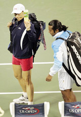 Martina Navratilova and Leander Paes leave the court after losing their mixed doubles match against Alicia Molik and Todd Woodbridge
