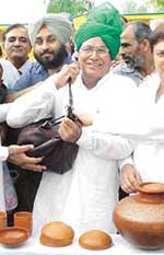 Haryana Chief Minister Om Prakash Chautala carries a mushk containing sacred water at Sodhra village in Pakistan on Saturday.