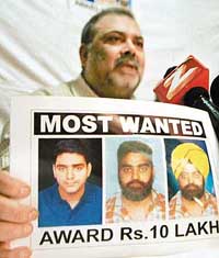 Vijay Narula, whose wife and daughter were murdered in the USA, shows the photo of accused Lovkesh during a press conference at the Press Club, Chandigarh