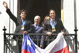 Chilean tennis players Fernando Gonzalez and Nicolas Massu wave to fans from a balcony
