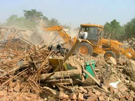 A buldozer pulls down illegal temporary and permanent structures which had come up on PUDA land in Bathinda