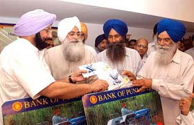 Punjab Chief Minister Amarinder Singh hands over an electronic kisan card after these were launched by the Bank of Punjab in Chandigarh