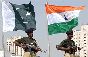 Anti-terrorist commandos stand on guard in front of Indian and Pakistani flags during a practice session at Karachi's National stadium on Thursday
