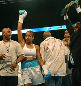 Laila Ali raises her glove after knocking out Gwendolyn