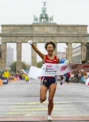 Japan's Yoko Shibui raises her fist as she crosses the finish line