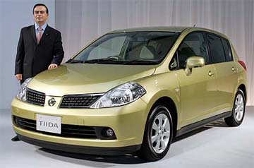 Nissan Motor President and Chief Exective Officer Carlos Ghosn poses with the new Tiida compact hatchback in Tokyo on Thursday.  Nissan launched the car in the Japanese market with a starting price of 1.428 million yen (about $ 12,880).  