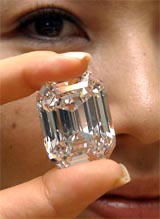 Model Tomoko Misawa shows off the reportedly world�s most valuable diamond in Tokyo on Friday. The diamond is certified as 100-carat, D-color and flawless and will be on a special display at a Tokyo department store with a price tug of 2.94 billion yen ($26.6 million) from October 9. 