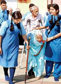 Schoolchildren accompany members of ‘Aasra Old Age Home’ for a picnic on International Elders Day in Bhopal on Friday.