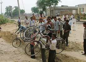 Cyclists crossing a pit dug up for constructing a wall by the raiilway authorities near the grain market in Bathinda