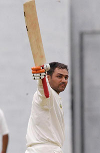 Virender Sehwag of India Seniors lifts his bat after scoring a century