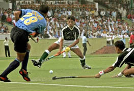 India�s Tushar Khandekar hits the ball as Pakistan players Zeeshan Ashraf and Tariq Aziz try to intercept