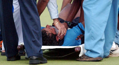 Indian captain Dilip Tirkey receives first aid after he was hit by a rising ball during the hockey Test at the National Stadium in New Delhi