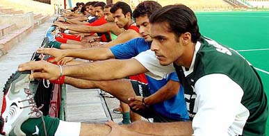 Members of the Pakistan hockey team perform stretching exercises during a training session at the Sector 42 hockey stadium in Chandigarh