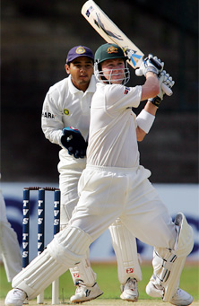Michael Clarke hits a shot as wicket keeper Parthiv Patel looks on