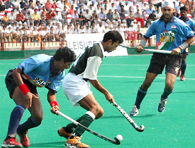 Indian players vie for the ball with a Pakistani player during the sixth hockey Test in Chandigarh