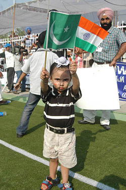 A child waves national flags of India and Pakistan at Guru Hargobind stadium 