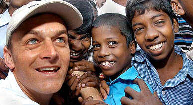 Australia's cricket captain Adam Gilchrist interacts with slum children
