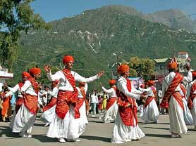 Folk artists dressed in traditional attire perform a local dance