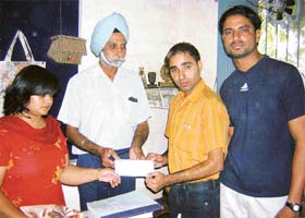 "Philanthropist" Jaskaran Singh Randhawa gives away the cheque for Rs 5 lakh to Col (retd) Karminder Singh, the head of a school for deaf and dumb, Amar Ashram, Patiala