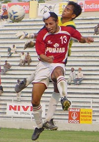 Baldeep Singh of Punjab fights for the ball with Tamil Nadu goalkeeper P Sathees Kumar during their quarterfinal match of the Santosh Trophy at Ambedkar Stadium