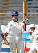Sri Lankan batsman Kumar Sangakkara raises his bat after scoring a century
