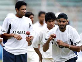 Harbhajan Singh prepares to bowl as Anil Kumble looks on during a training session in Mumbai