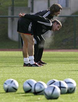 German national players Moritz Volz  and Thomas Brdaric stretch during a practice session in the eastern German town of Leipzig 