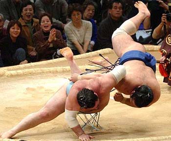 Kokkai flips Tochiazuma during their bout at the Kyushu Grand Sumo tournament in Fukuoka, western Japan, on Tuesday