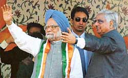 Prime Minister Manmohan Singh and Chief Minister of Jammu and Kashmir Mufti Mohammad Sayeed wave to people during a public meeting in Srinagar on Wednesday.