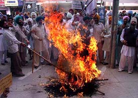 The activists of the BKU (Ekta) burning the effigy of chairman of Cotton Corporation of India in front of its office at Bathinda on Wednesday