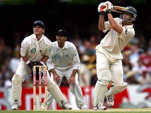Australia�s Adam Gilchrist hits a six as New Zealand�s Brendon McCullum (L) and Stephen Fleming look on during the third day�s play of the first Test in Brisbane on Saturday.