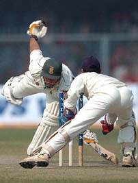Indian wicketkeeper Dinesh Karthick makes an unsuccessful attempt to run out South African batsman Jacques Kallis on the first day of the first Test in Kanpur on Saturday.
