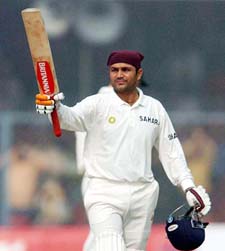 Indian batsman Virender Sehwag celebrates after completing his century on the fourth day of the first Test between India and South Africa in Kanpur