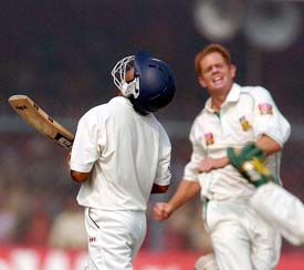 South Africa's bowler Shaun Pollock exults as Indian opener Gautam Gambhir walks back to the pavilion