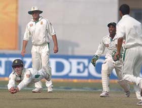 Boeta Dippenaar takes a diving catch off Harbhajan Singh as team-mates look on on the last day of the first Test between India and South Africa in Kanpur