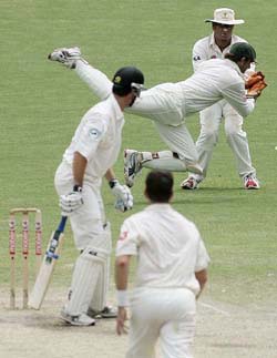 Australian wicketkeeper Adam Gilchrist dives across teammate Shane Warne to take a catch to dismiss New Zealand batsman James Franklin on the last day of the second Test in Adelaide on Tuesday