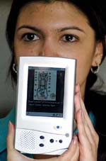 A girl holds a Simputer, a low cost hand device developed by Encore Software, at a press conference in Bangalore on Wednesday.