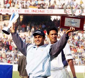 Man-of-the-match Virender Sehwag shows his trophies as Anil Kumble looks on during the prize distribution ceremony in Kolkata on Thursday