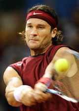 Spain�s Carlos Moya returns a backhand to Mardy Fish of the USA during the first match of the 2004 Davis Cup final at Seville�s Olympic Stadium 