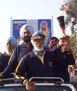 Hockey Olympian and former chief coach of the Indian squad, Balkishen Singh, holding aloft the Indo-Pak Games torch which arrived at Patiala