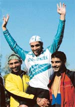 Pavittar Singh of Punjab (India) celebrates after winning the gold medal in the mass start 6km race at the Punjabi University stadium in Patiala on Monday