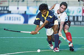 Arjun Halappa is tackled by German defender Eike Duckwitz during the Champions Trophy Hockey match at Lahore on Tuesday.