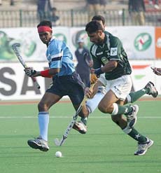 Pakistan's Shakeel Abbasi (right) and India's Prabodh Tirkey in action during their Champions Trophy hockey match in Lahore on Wednesday.