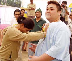 A student of St. Frances College tries to push a Japanese Sumo wrestler during a show of strength